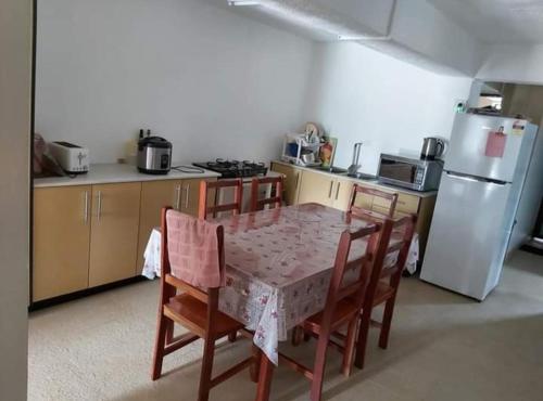 uma cozinha com uma mesa e cadeiras e um frigorífico em Barrett Accommodation Rooms em Suva