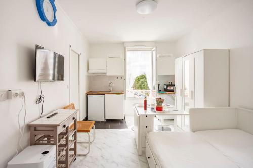 - une cuisine blanche avec un lit et un bureau dans l'établissement Paris tourist Apartment, France, à Stains