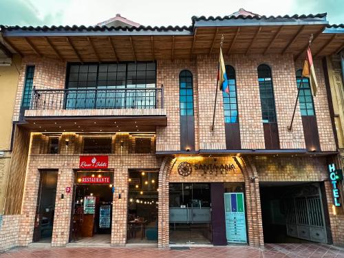 a large brick building with flags in front of it at Grand Hotel Santa Ana in Cuenca