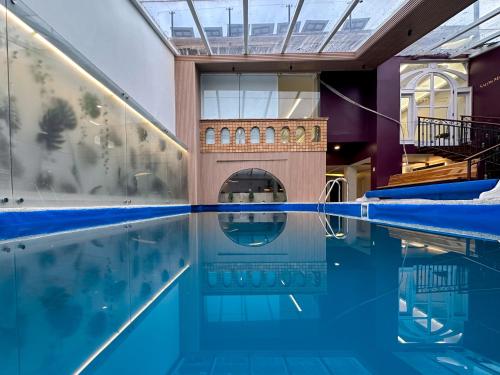 una piscina cubierta con suelo de baldosa y un edificio en Grand Hotel Santa Ana, en Cuenca