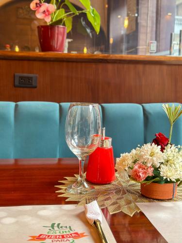 a table with a wine glass and flowers on it at Grand Hotel Santa Ana in Cuenca