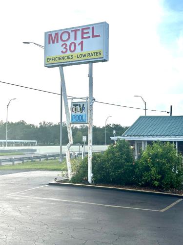 a motel sign in a parking lot next to a building at Motel 301 in Tampa