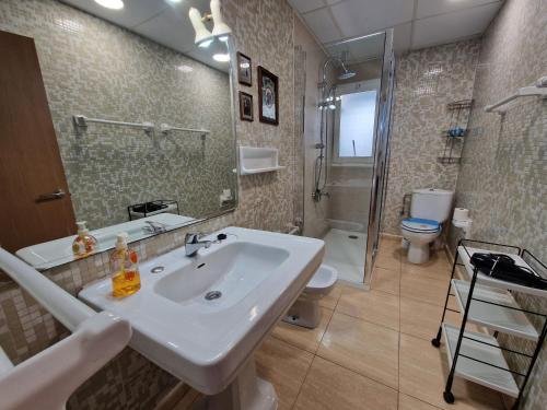 a bathroom with a sink and a shower and a toilet at Apartamento JMAP in Salou