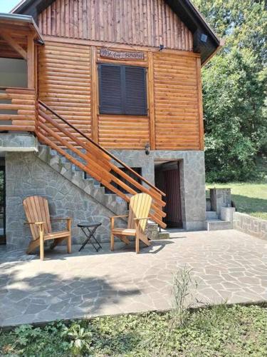 two wooden chairs sitting outside of a building at Vila Vera in Vršac
