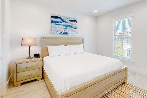 a white bedroom with a bed and a lamp at Villa Lago 1969 Baytowne Loop in Destin