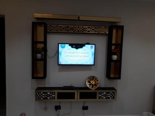 Cette chambre comprend un miroir mural et une télévision. dans l'établissement Khaled new home, au Caire