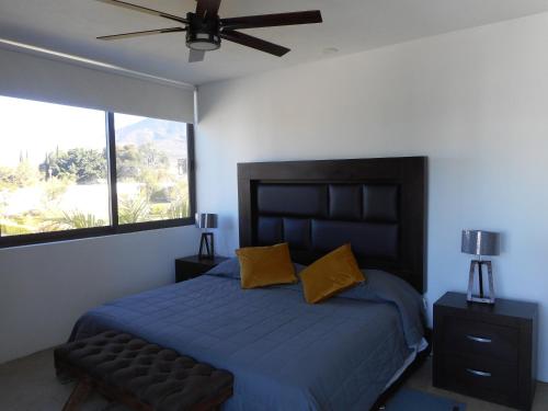 um quarto com uma cama com lençóis azuis e almofadas amarelas em Hermosa Casa en Orilla del lago -Zona de villedos- em San Cristóbal Zapotitlán