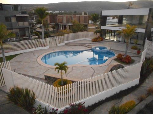 uma grande piscina com uma cerca branca à volta em Hermosa Casa en Orilla del lago -Zona de villedos- em San Cristóbal Zapotitlán