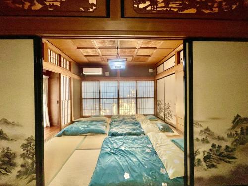 una camera con un grande letto al centro di T&T Fujiyama Guest House a Fujiyoshida