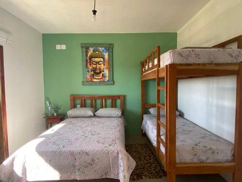um quarto com 2 beliches e uma pintura na parede em Pousada Recanto Mandalah em Cunha