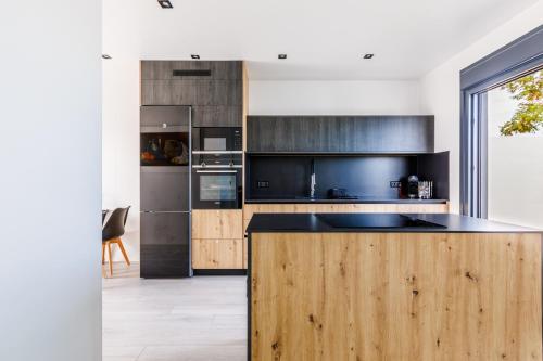 a kitchen with wooden cabinets and a black counter top at Ocean House Torre del Mar in Torre del Mar
