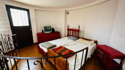 ein Schlafzimmer mit einem Bett und einem Fernseher darin in der Unterkunft Casa grande 5 pax San Antonio de Arredondo CORDOBA in San Antonio de Arredondo