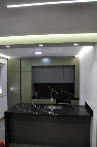 a kitchen with a black counter with a sink at City apartment 101 in Shkodër