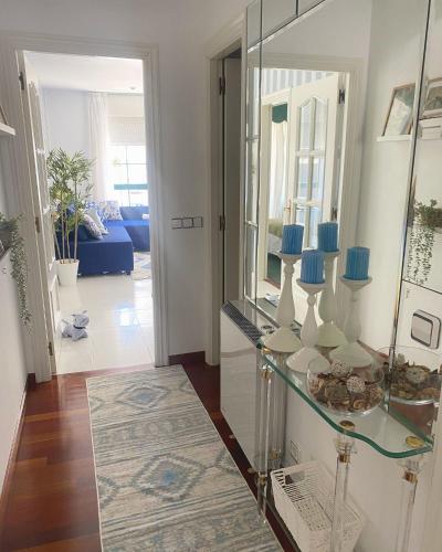 een hal met een glazen tafel en een spiegel bij Apartamento San Roque in Betanzos