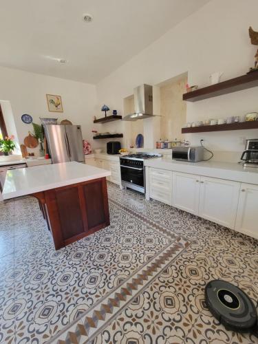 a large kitchen with white cabinets and a tile floor at Hacienda San Jose Poniente in Hoctún