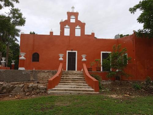 an orange building with stairs in front of it at Hacienda San Jose Poniente in Hoctún