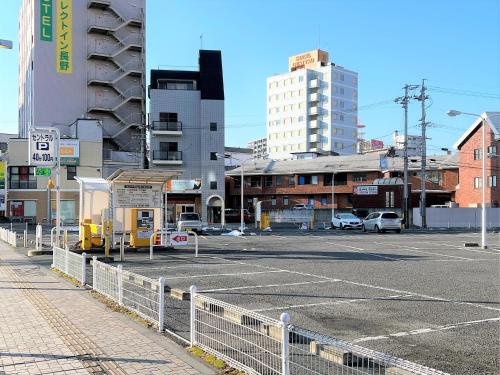 an empty parking lot in a city with buildings at Hotel JAL City Nagano in Nagano