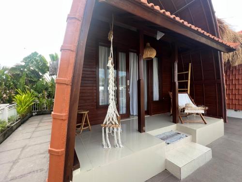a porch of a house with a giraffe statue on it at Shortcut Breeze Guest House in Canggu