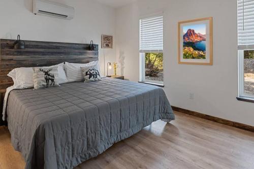 a bedroom with a bed and two windows at Luxe Mt. Rainier Lodge w/ Hot Tub-AC-Game Room in Ashford