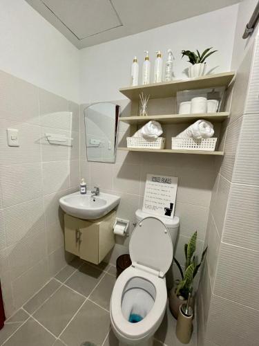 a bathroom with a toilet and a sink at Sebby Studio in Bacolod