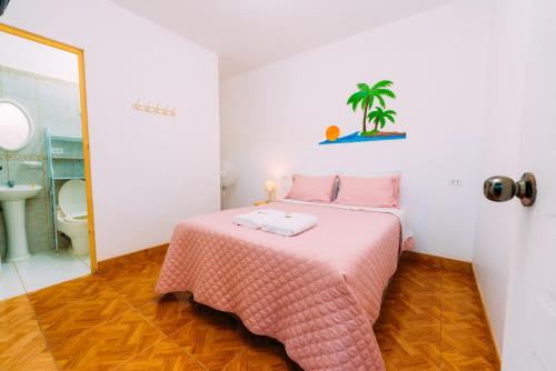a bedroom with a pink bed and a bathroom at Hospedaje Mary in Paracas