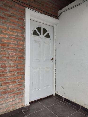 a white door on the side of a brick wall at comodoro sur in Comodoro Rivadavia