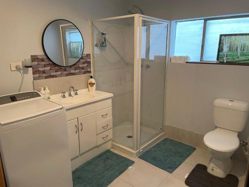 a bathroom with a shower and a toilet and a sink at Quaint Flat, Outside Dog Friendly, near hospital in Geraldton