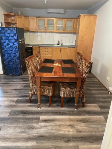 a kitchen with a wooden table and chairs at Central Shenton unit Outside Dog Friendly, near hospital in Geraldton