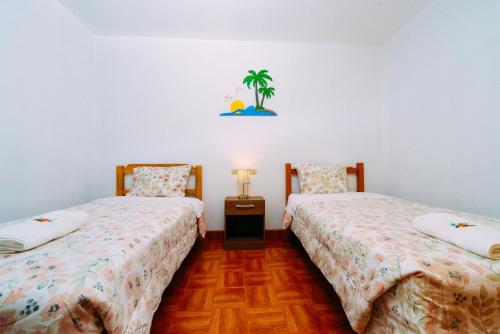 パラカスにあるHospedaje Maryのベッド2台が隣同士に設置された部屋です。