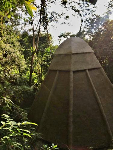 a stone monument in the middle of a forest at Kasaguadua - RESERVA NATURAL in Salento