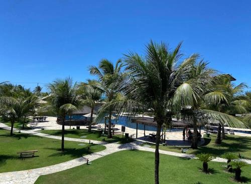 a park with palm trees and a body of water at Ap no Beach Place Resort in Aquiraz
