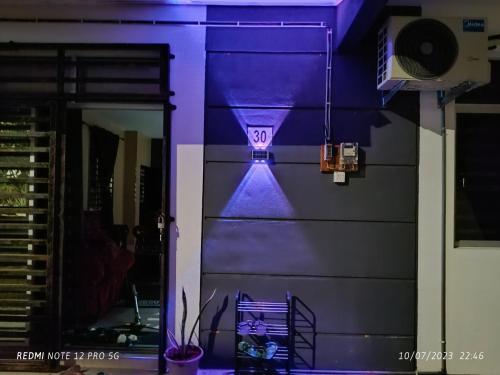 a purple room with a clock on the wall at Cinoiva Homestay Gambang, Kuantan in Gambang