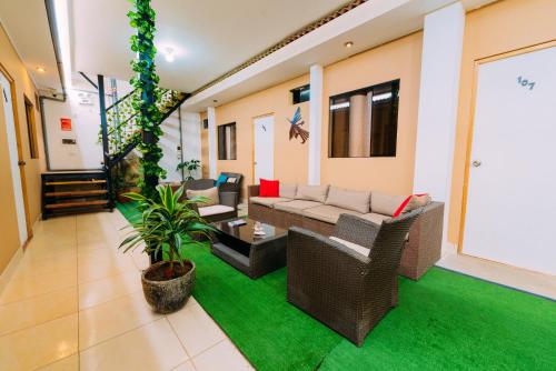 a living room with couches and a green rug at Hospedaje Mary in Paracas
