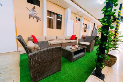 a living room with a couch and chairs on grass at Hospedaje Mary in Paracas