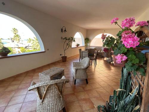 a living room with chairs and pink flowers at Dormo Da Lia Borgo San Nicola in Mandra Capreria