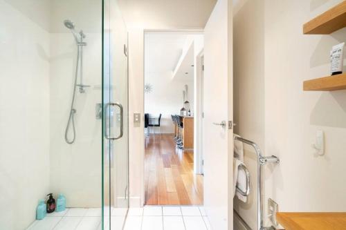 een badkamer met een douche en een glazen deur bij The Landings Parnell in Auckland