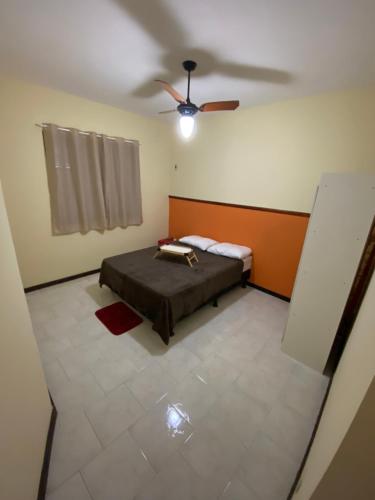 a bedroom with a bed and a ceiling fan at Orange House Itaipuaçu in Maricá