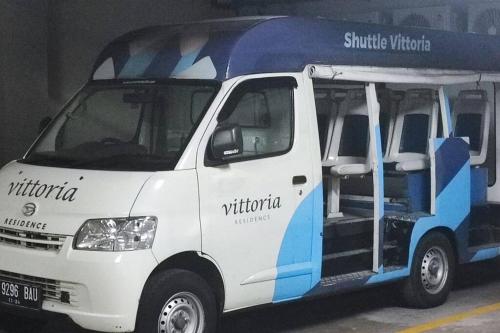 a white and blue bus parked in a parking lot at busy city street in Cihuni