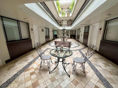 a room with a glass table and two chairs at Grand Hotel Santa Ana in Cuenca