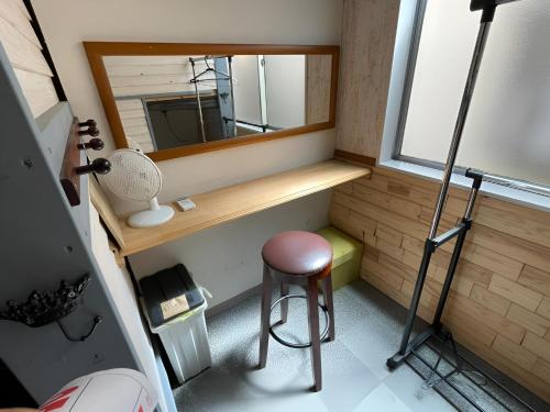 a small room with a stool and a mirror at まちやど　Motomachi in Daigo
