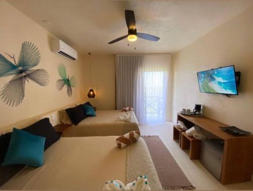 sunsteps dragonfly room في جزيرة هول بوكس: غرفة نوم بسريرين ومروحة سقف