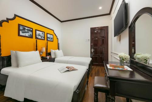 a hotel room with two beds and a desk at Silk Castle Hotel & Spa - Hanoi Old quarter in Hanoi