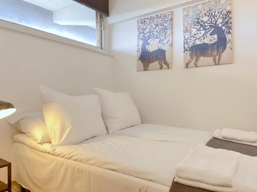 a white couch in a room with two paintings on the wall at One Bedroom Apartment In Rdovre, Trnvej 41a, in Rødovre