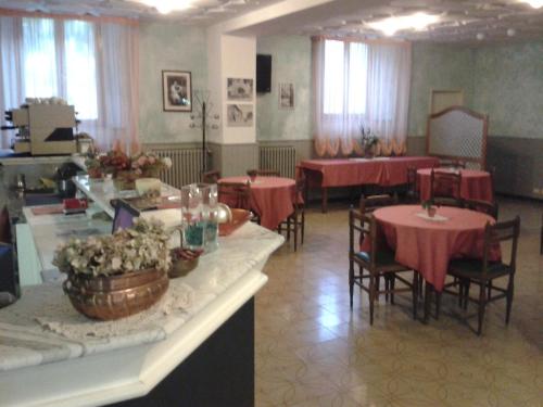 a dining room with tables and chairs with red table cloth at Hotel Italia Abbadia in Abbadia San Salvatore