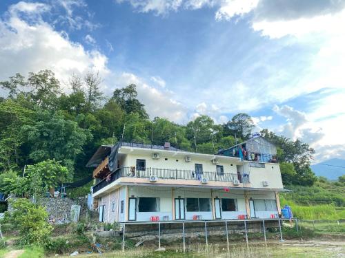a large white house on top of a hill at Du Già Lô Lô Homestay in Làng Cac