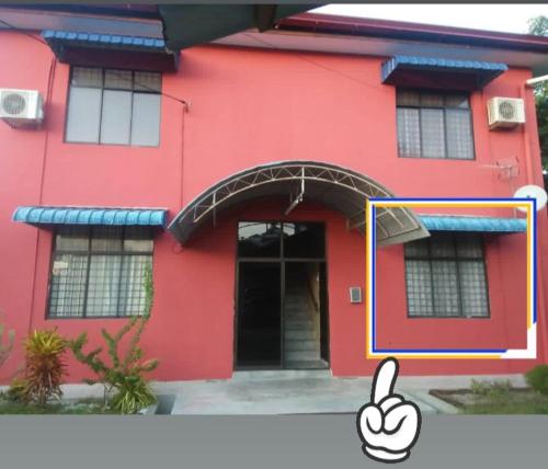 una casa roja con una mano dando un pulgar hacia arriba en Homestay Bandar Batu Pahat en Batu Pahat