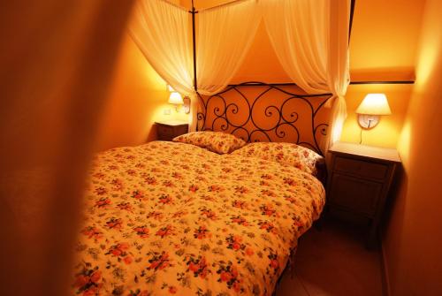 インペリアにあるDa Tizianaのベッドルーム1室(花柄のベッドカバー、ランプ2つ付)