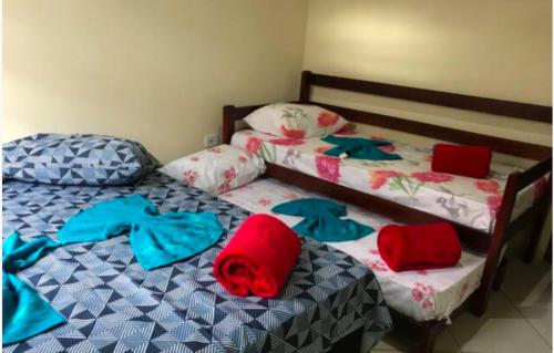 2 camas individuales en un dormitorio con toallas. en Casa Campos, en Paraty