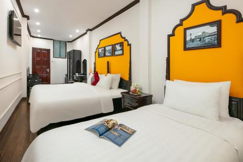 two beds in a room with two white beds at Silk Castle Hotel & Spa - Hanoi Old quarter in Hanoi