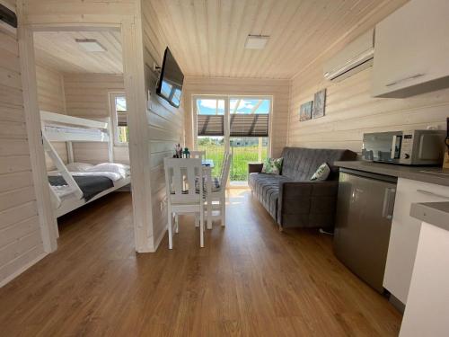a small living room with a couch and a bunk bed at Comfortable holiday houses D bki in Dąbki